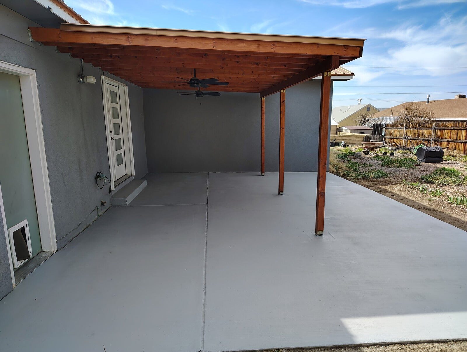Covered patio with stained wood-beam ceiling and sealed concrete floor