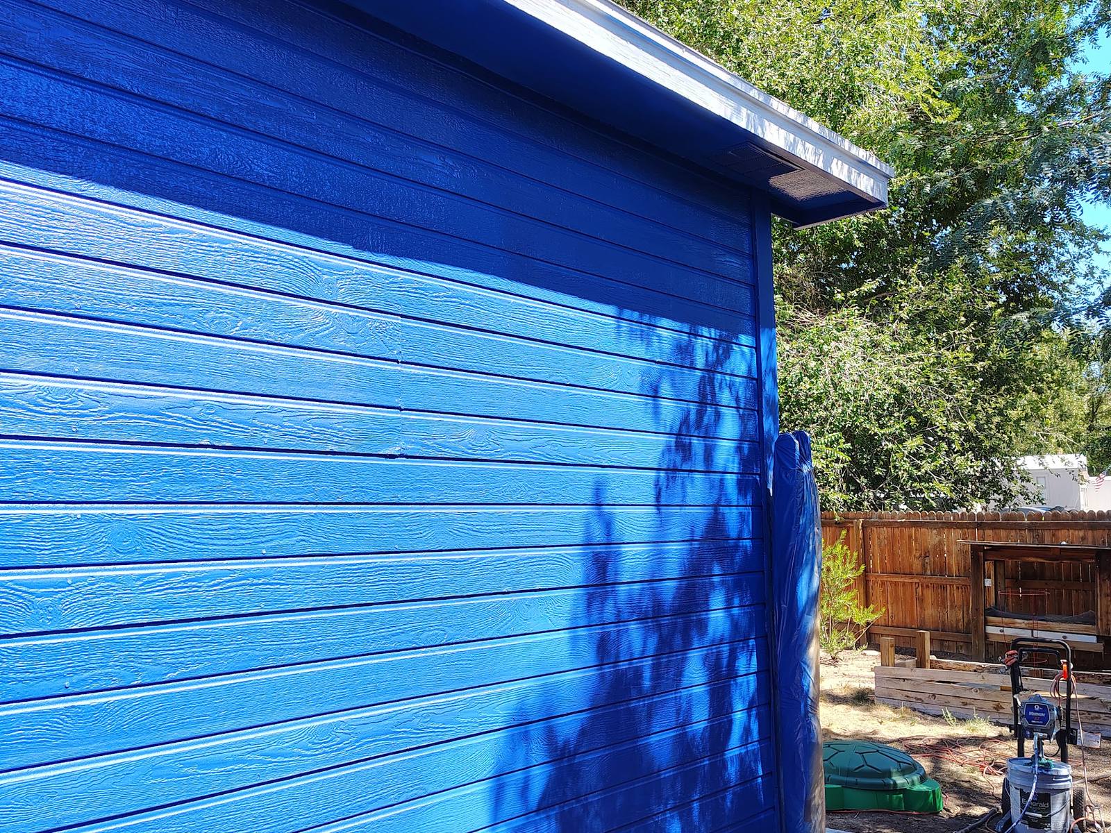 Deep blue lap siding freshly painted on a Bloomfield, NM home