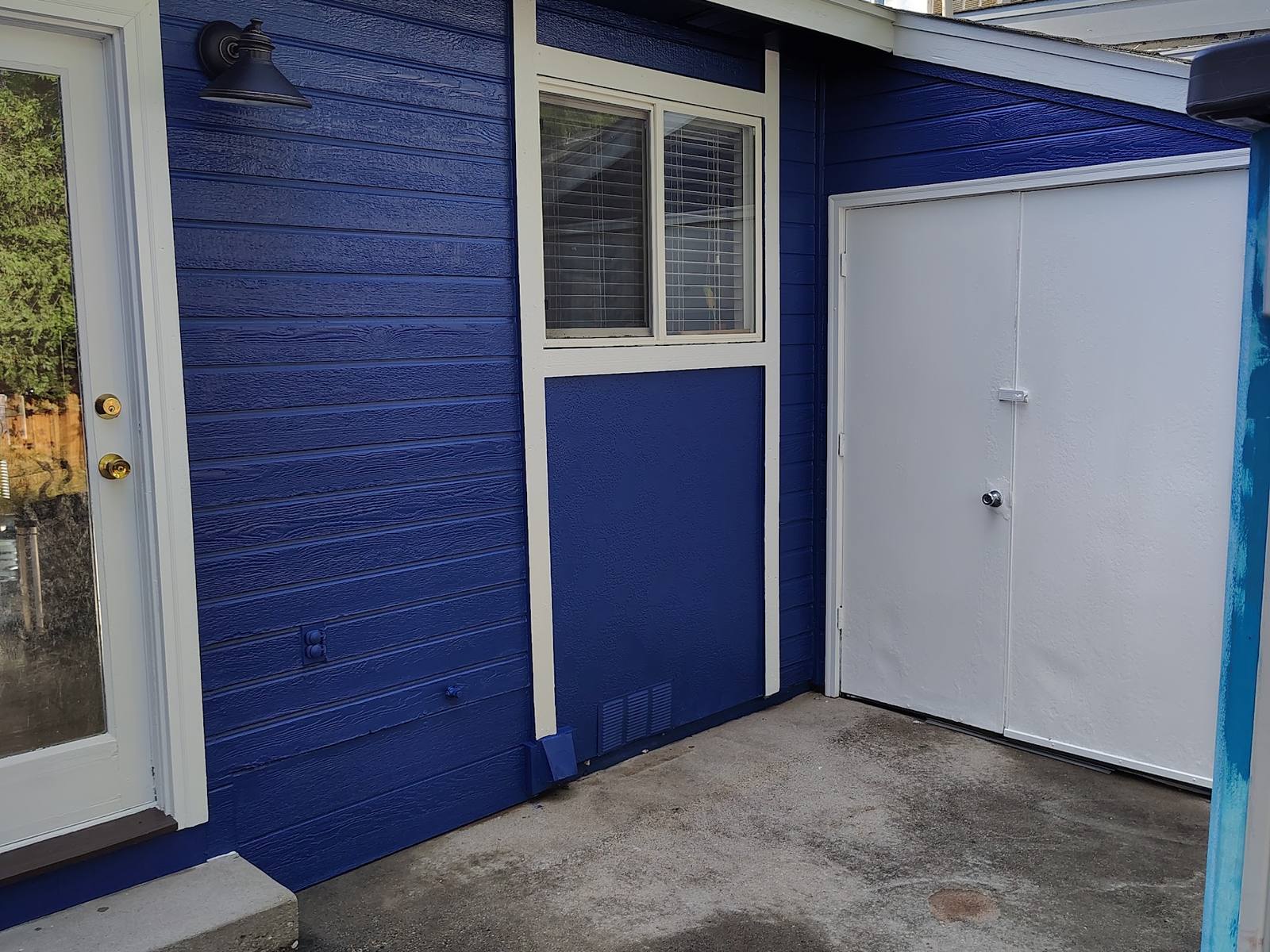 Repainted blue home exterior with white garage door and trim