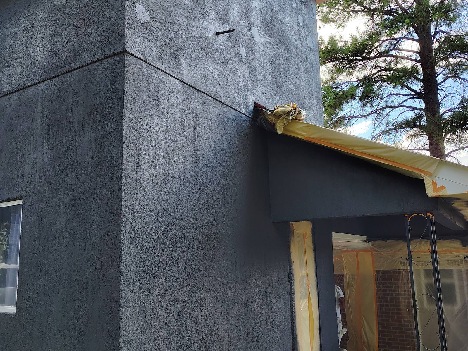 Two-story cottage finished in charcoal after stucco repair