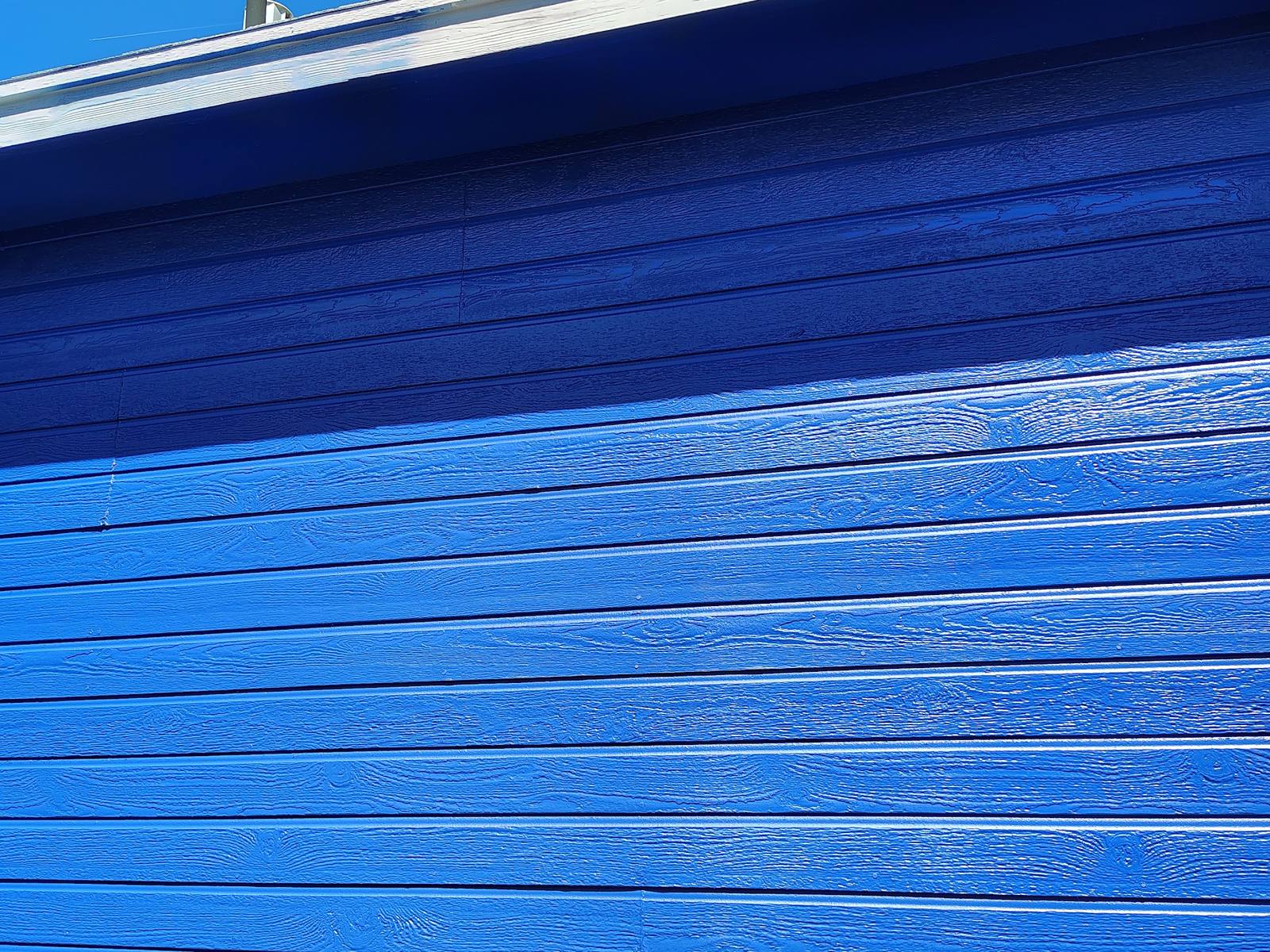 Close detail of freshly painted blue lap siding