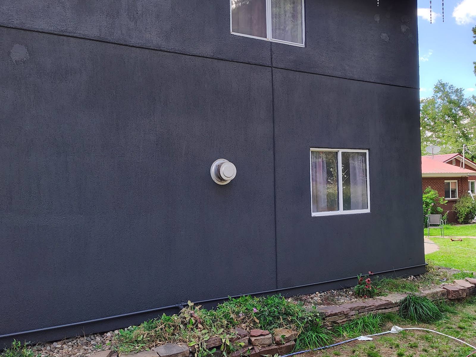 The same cottage wall finished in charcoal, patches invisible