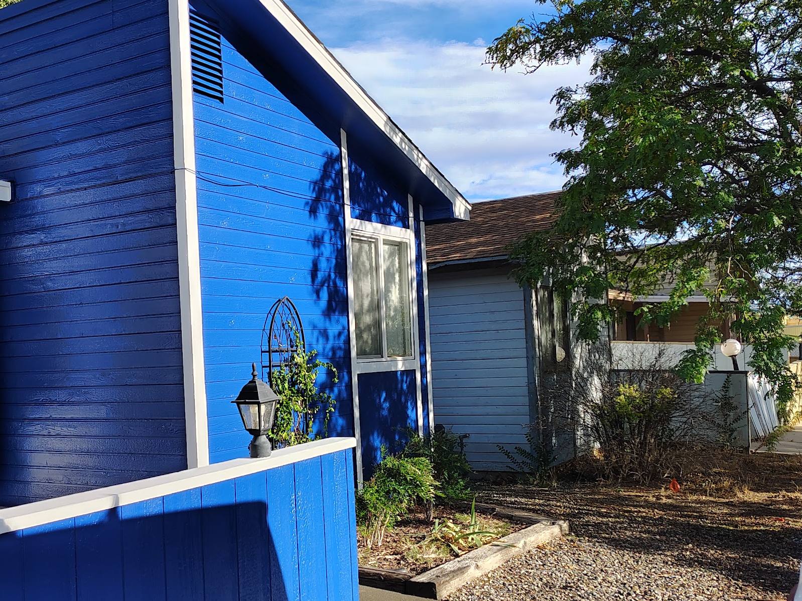 The finished house in two tones of blue under a clear sky